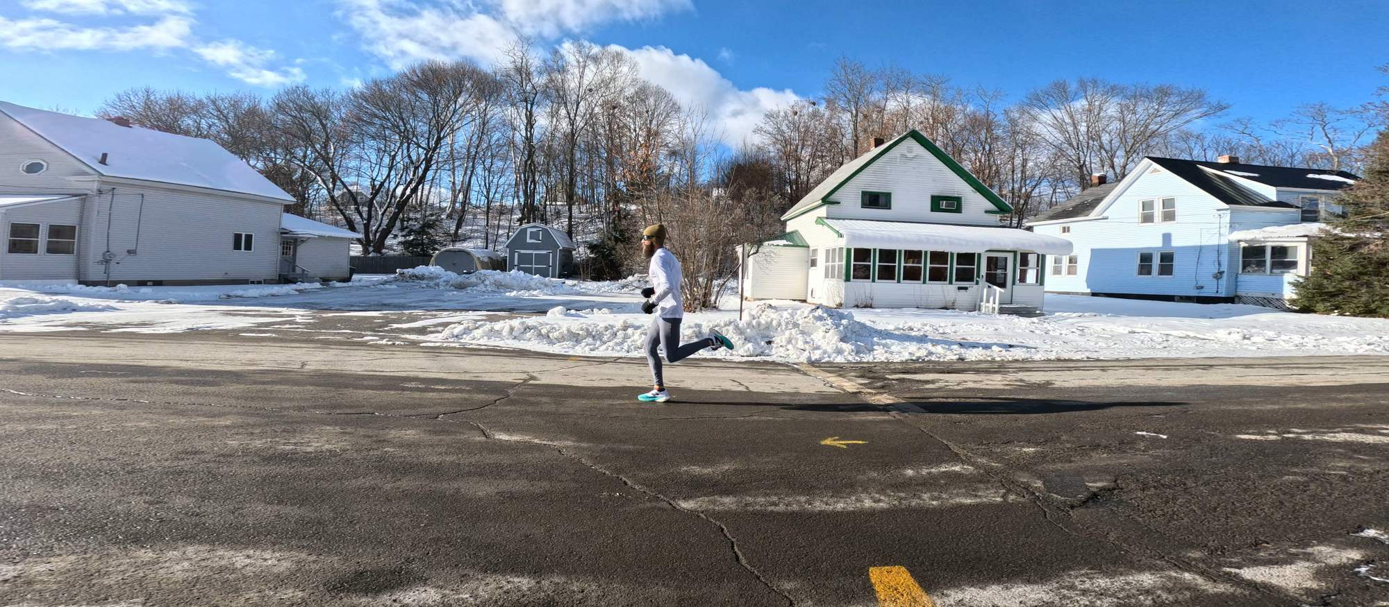 Runner passing snowy houses in Millinocket